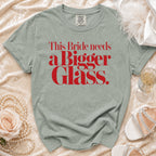 Light green Comfort Colors t-shirt with red text that reads "This Bride needs a Bigger Glass."