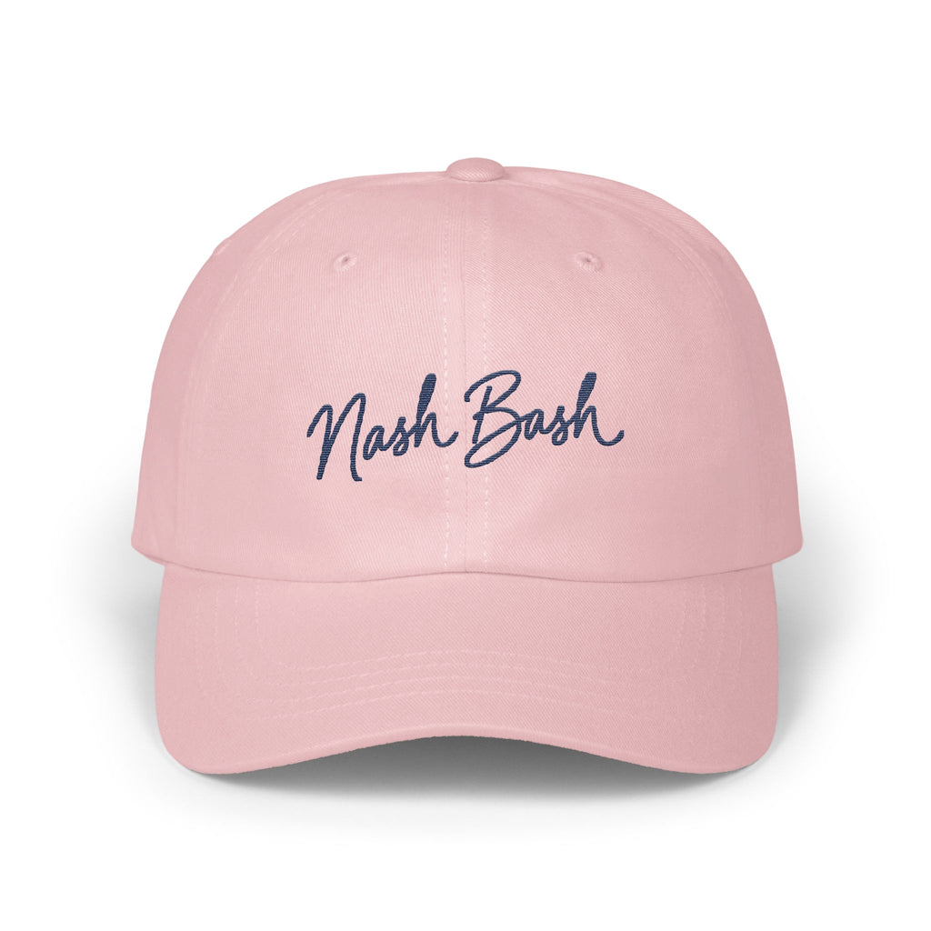 Light pink baseball cap with dark blue cursive text reading Nash Bash embroidered on the front.