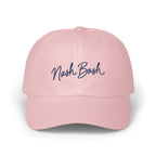 Light pink baseball cap with dark blue cursive text reading Nash Bash embroidered on the front.