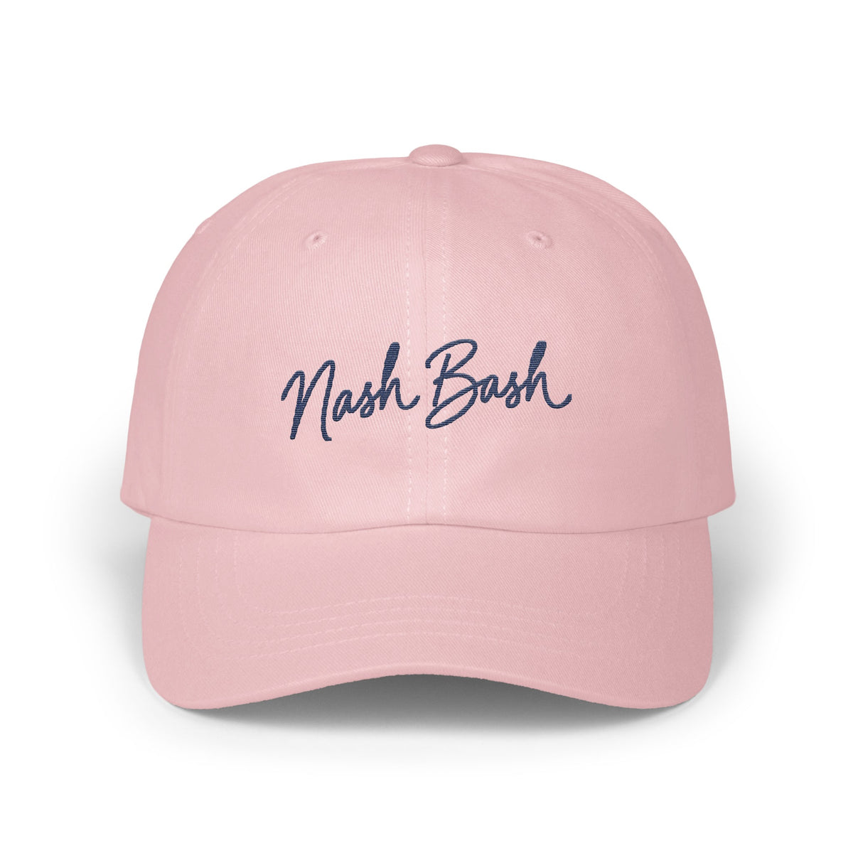 Light pink baseball cap with dark blue cursive text reading Nash Bash embroidered on the front.