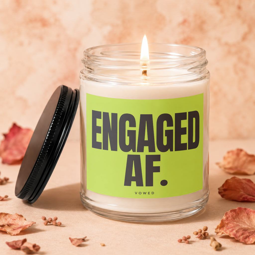 Glass jar candle burning with "ENGAGED AF." text on a bright green label.