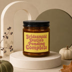Gilded candle with "Bridesmaid Duties Pending Complete" text on yellow label.
