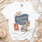 White t-shirt with "Reckless in Texas" and disco cowboy boot graphic.