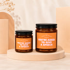 Two amber jar candles with black lids, labeled "You're Asked to Give a Speech".