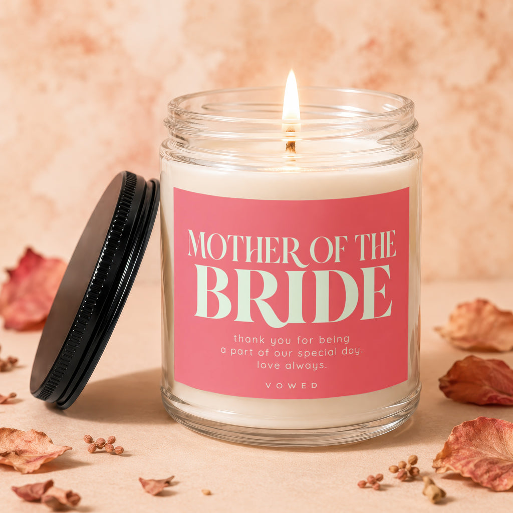 Candle with "Mother of the Bride" text, lid off, flame lit.
