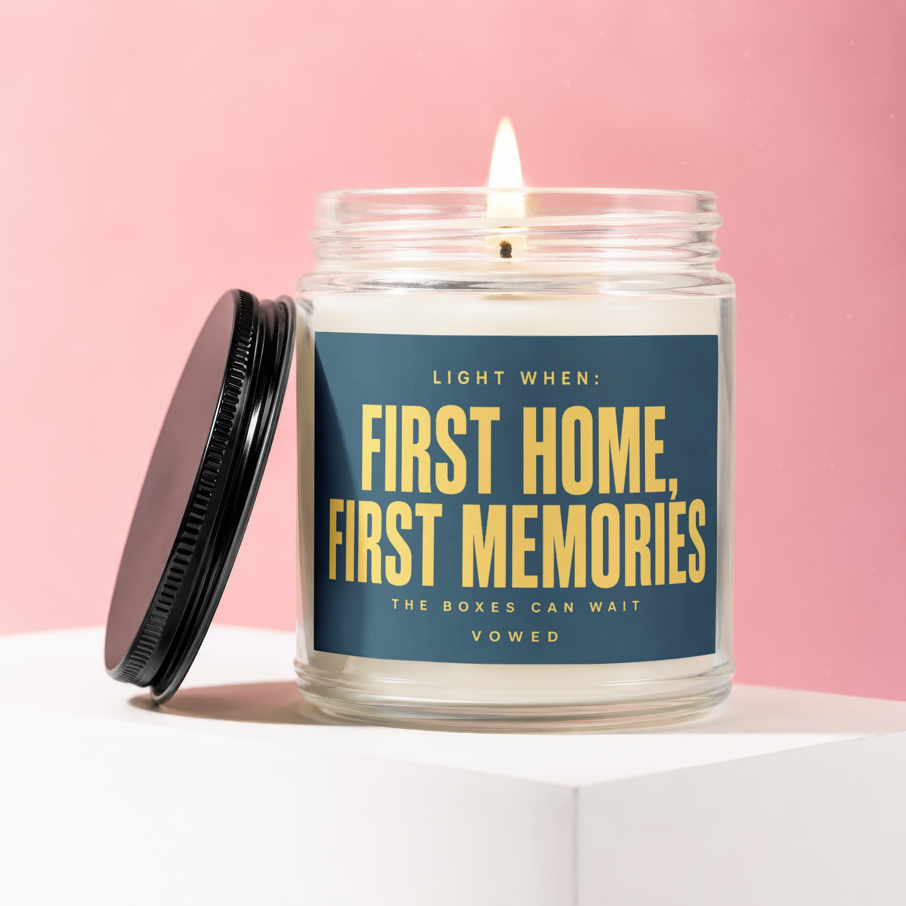 Glass candle with label "Light When: First Home, First Memories. The Boxes Can Wait."