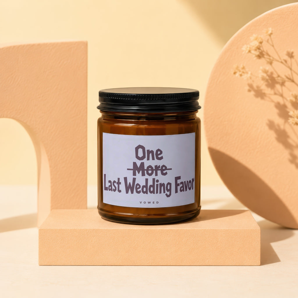 Amber jar candle with a black lid reading "One More Last Wedding Favor VOWED".