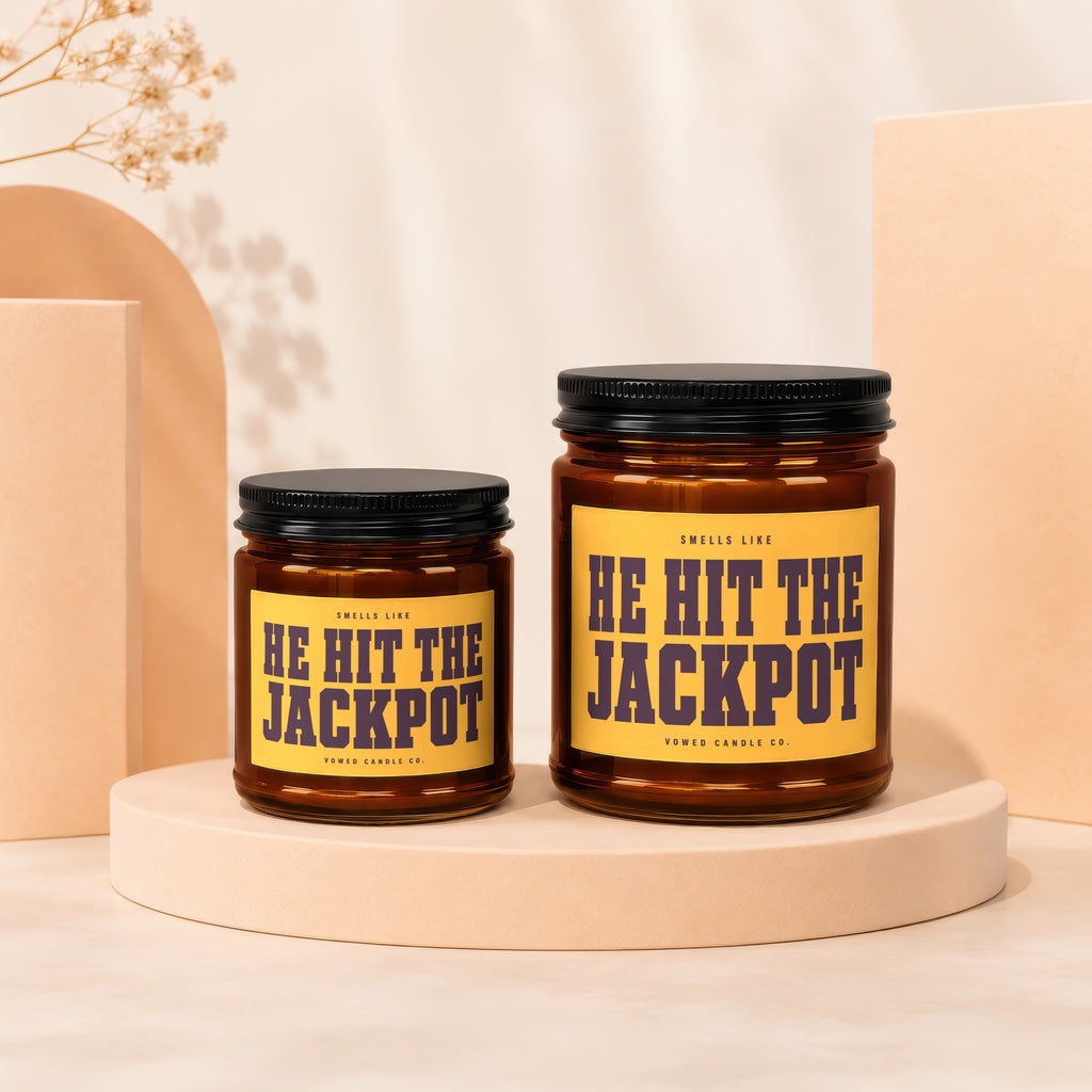 Two amber glass candles with yellow labels reading "HE HIT THE JACKPOT".