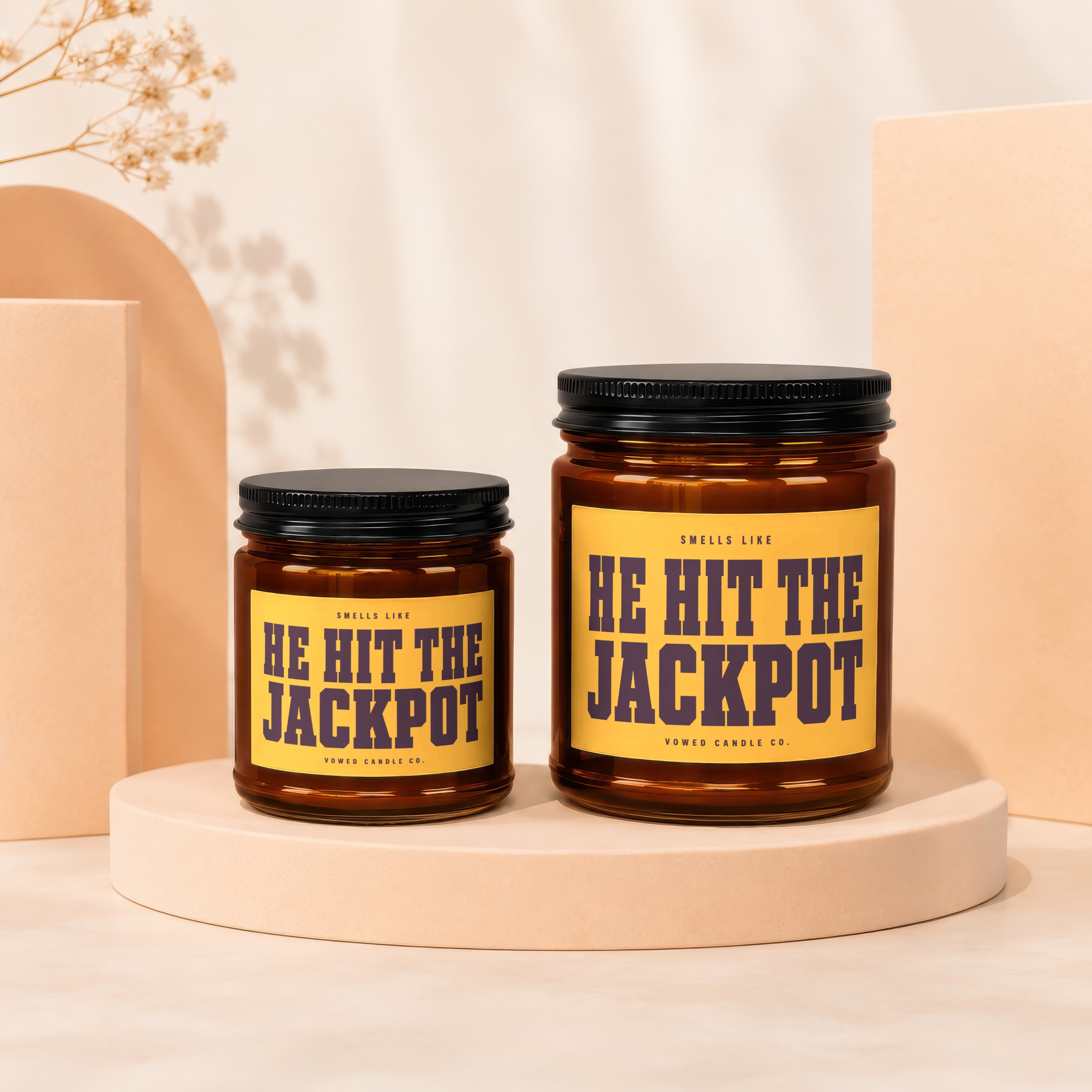 Two amber glass candles with yellow labels reading "HE HIT THE JACKPOT".