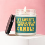 Glass candle with lit wick and black lid, labeled "My Favorite Daughter-In-Law Gave Me This Candle."
