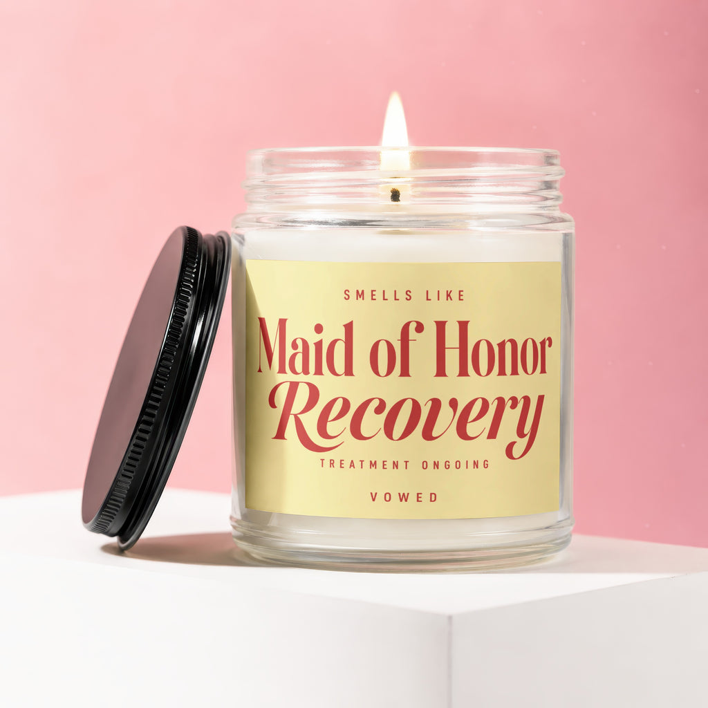 Candle with text "Maid of Honor Recovery" on a yellow label.