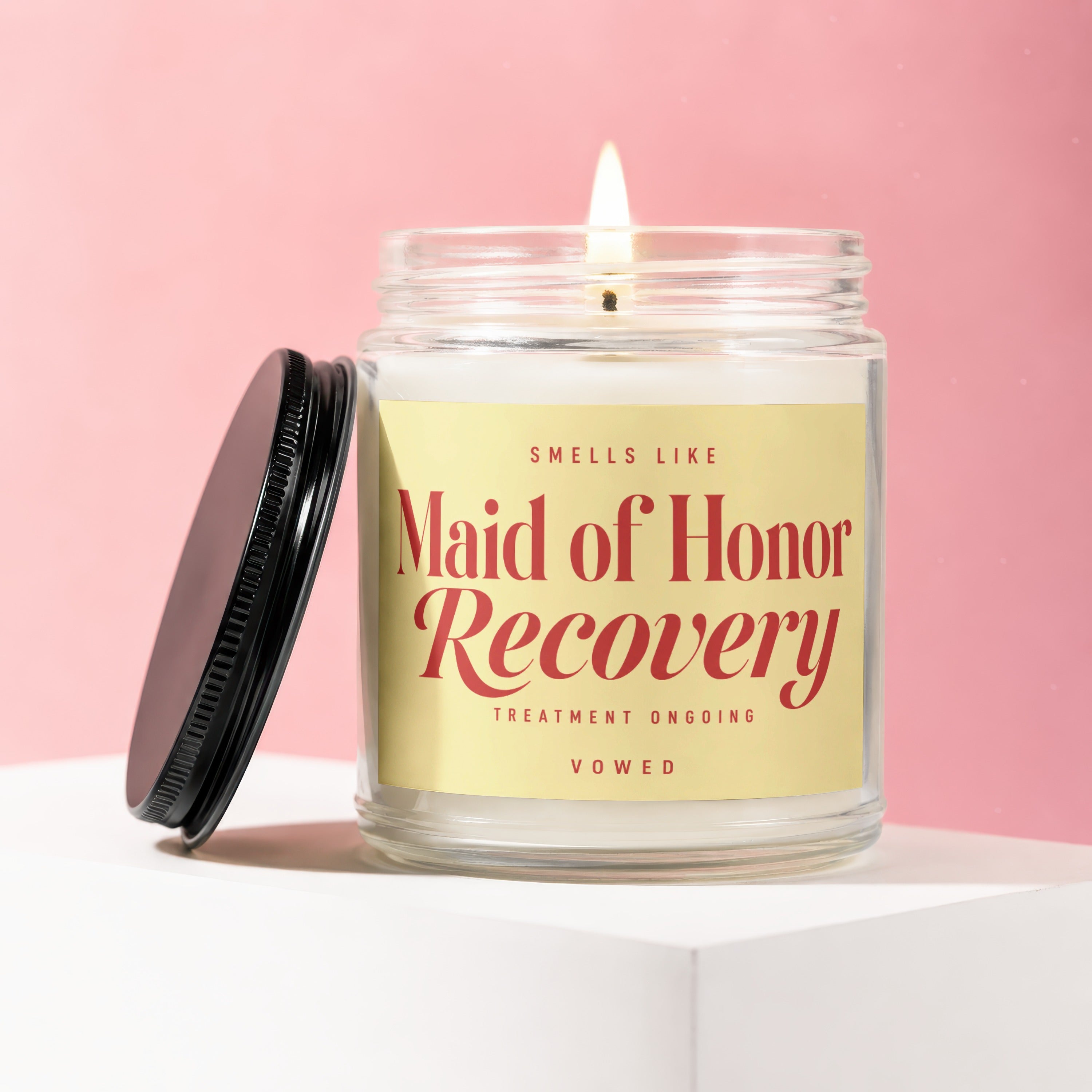 Candle with text "Maid of Honor Recovery" on a yellow label.
