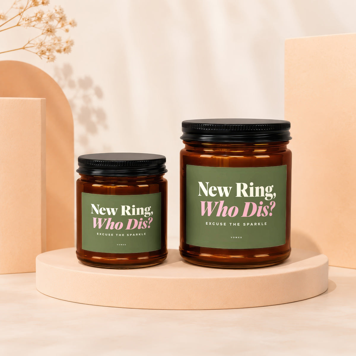 Two amber glass candles with green labels reading "New Ring, Who Dis?"