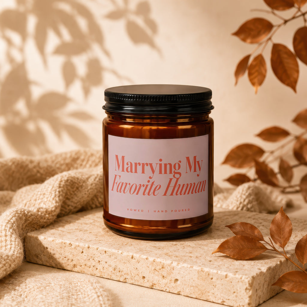 Amber glass candle with label reading "Marrying My Favorite Human. Vowed | Hand Poured."