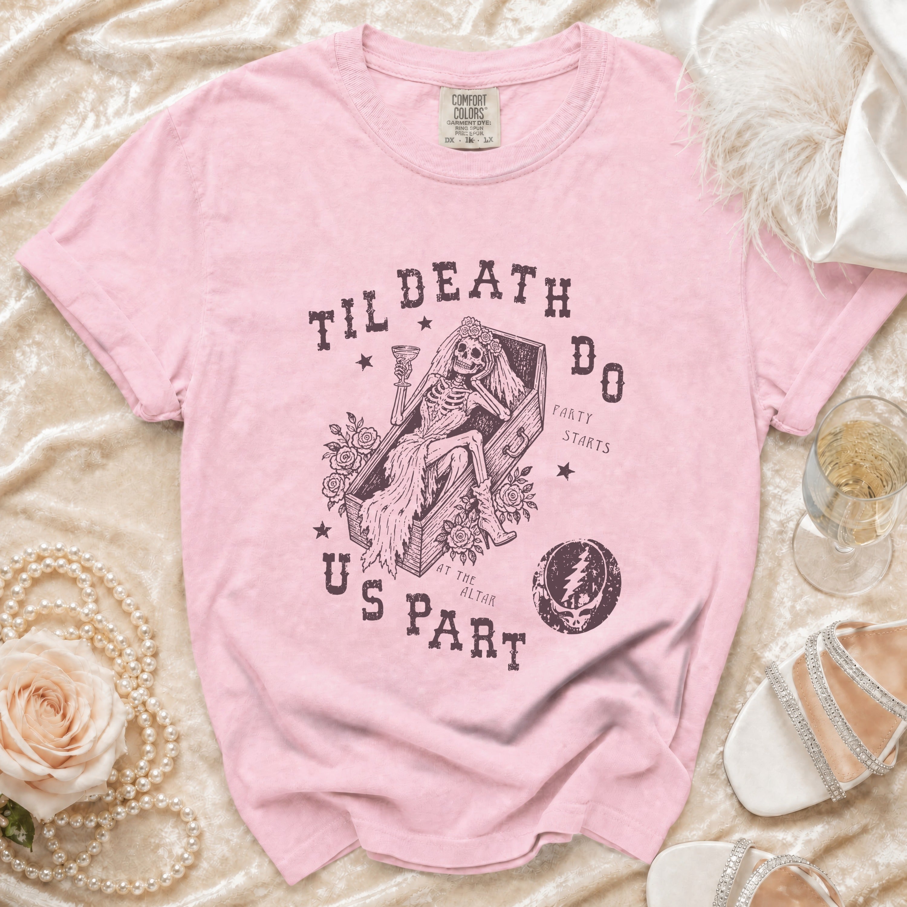 Pink t-shirt with skeleton bride in coffin graphic, "Til Death Do Us Part" text.