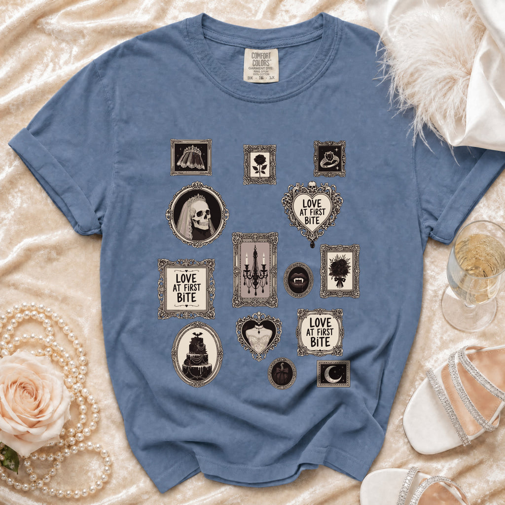 Blue t-shirt with framed gothic illustrations: skull bride, cake, and "Love at First Bite" text.