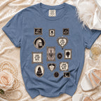 Blue t-shirt with framed gothic illustrations: skull bride, cake, and "Love at First Bite" text.
