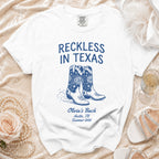 White t-shirt with "Reckless in Texas" and cowboy boots graphic.
