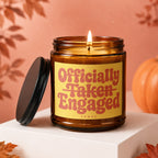 Amber jar candle with "Officially Taken Engaged" text on a yellow label.