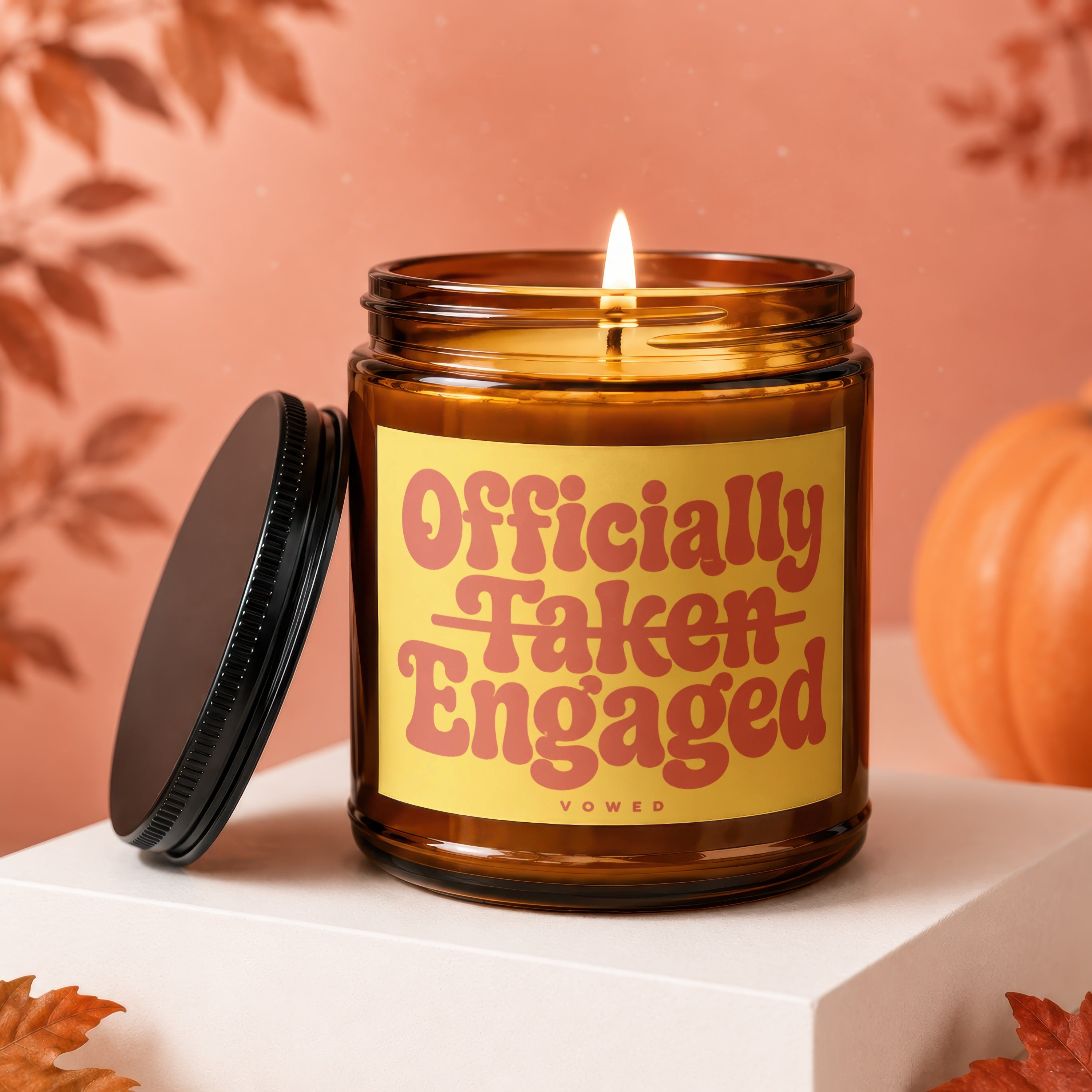 Amber jar candle with "Officially Taken Engaged" text on a yellow label.