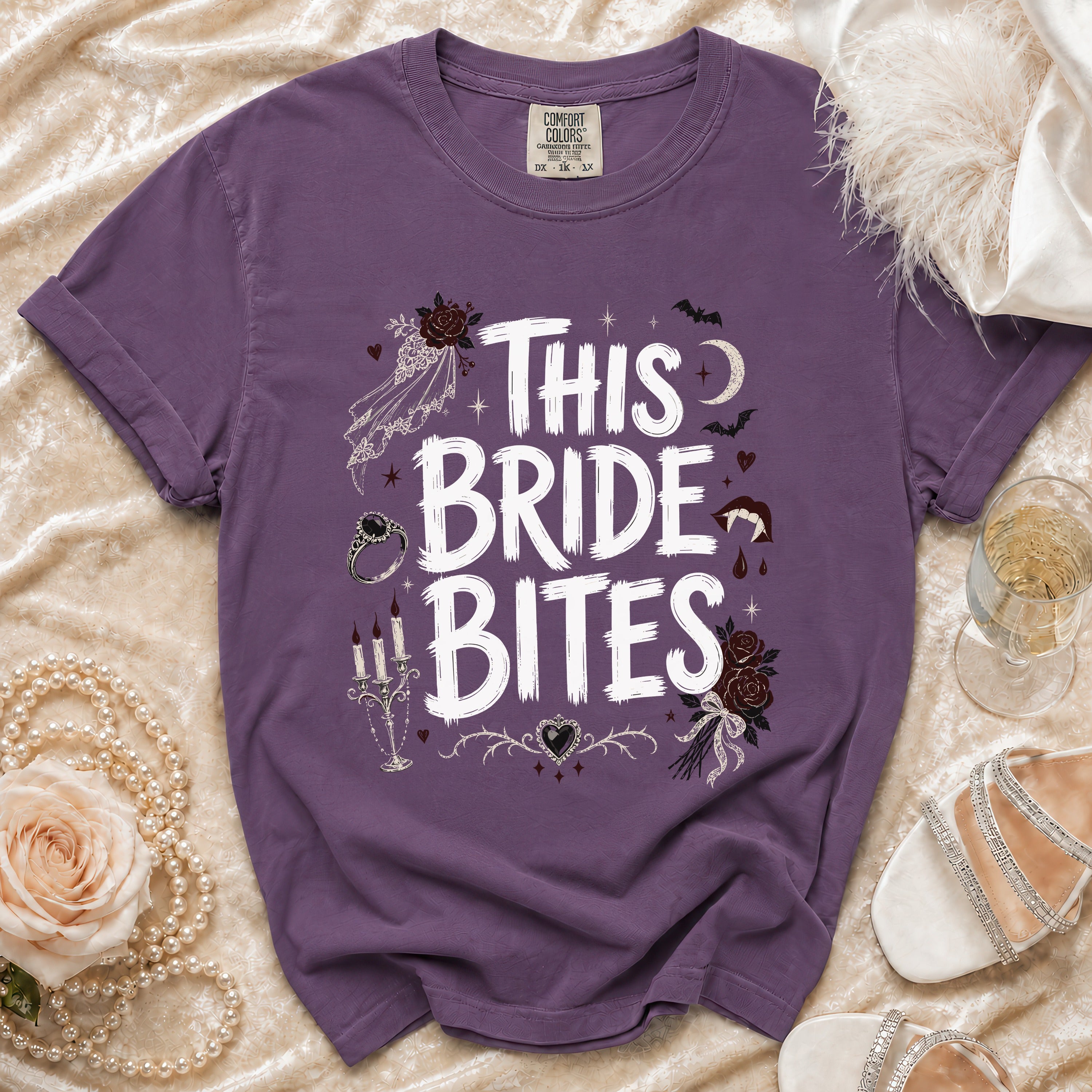 Purple t-shirt with "This Bride Bites" text and gothic wedding graphics.