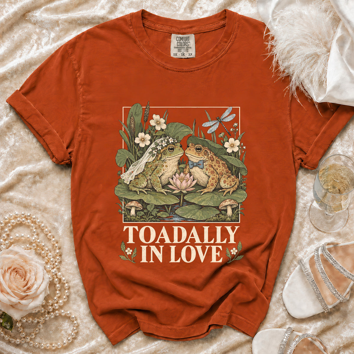Orange t-shirt with a graphic of two frogs in love and "Toadally In Love" text.