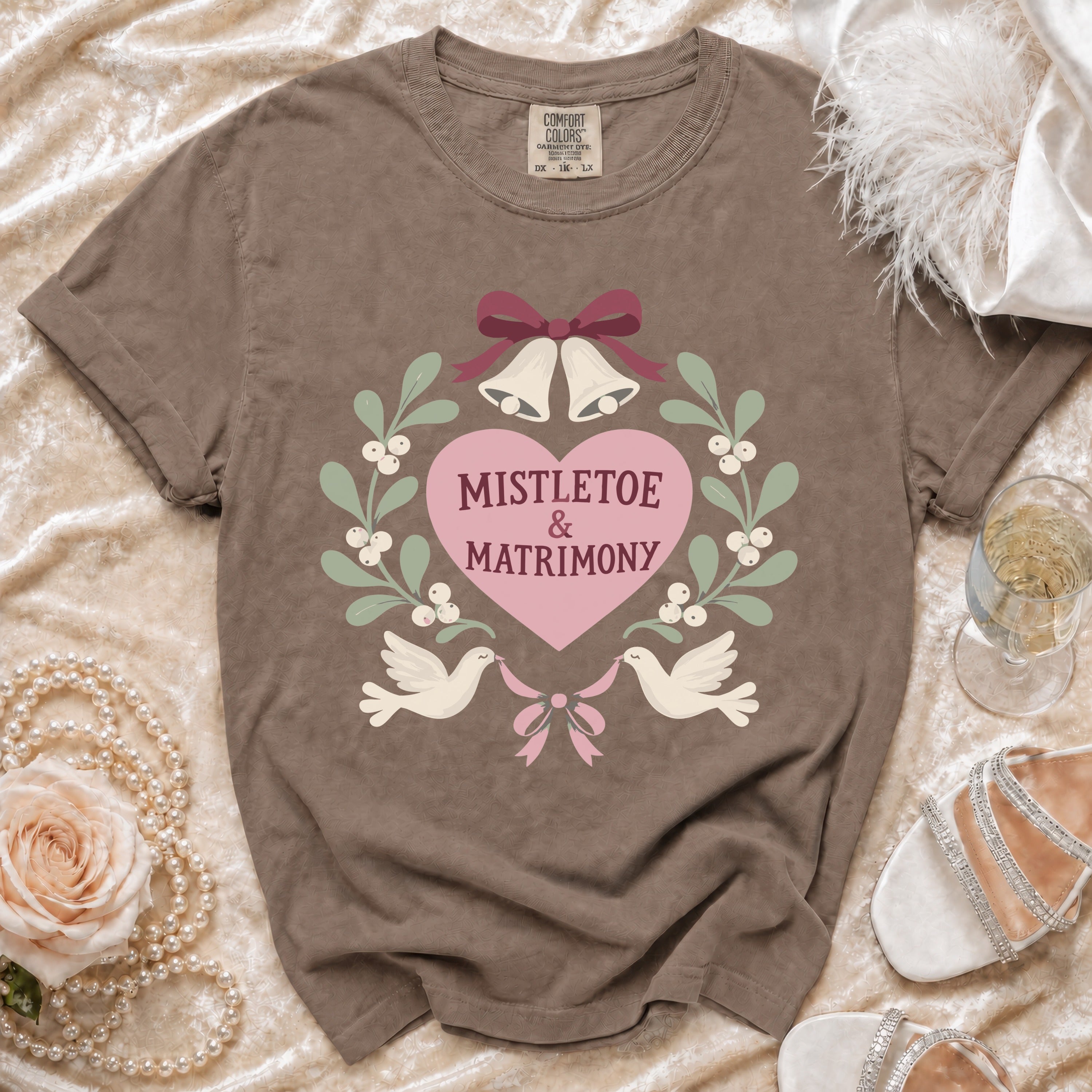 Brown t-shirt with "Mistletoe & Matrimony" text and wedding bells graphic.