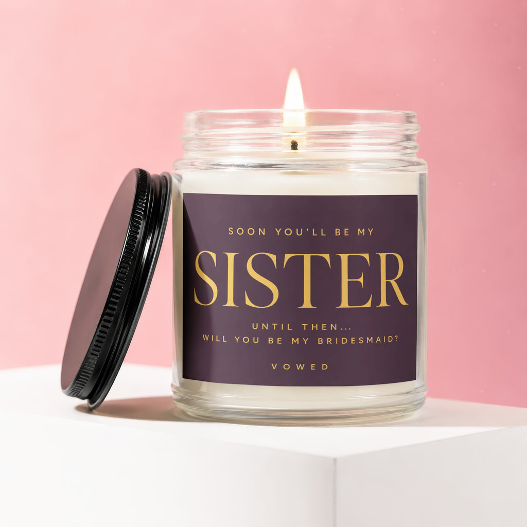 Glass candle with "Sister Will You Be My Bridesmaid?" text, lit wick.