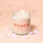 Lit candle, "My Favorite Yes" label, champagne and chaos notes, Vowed, Hand Poured.