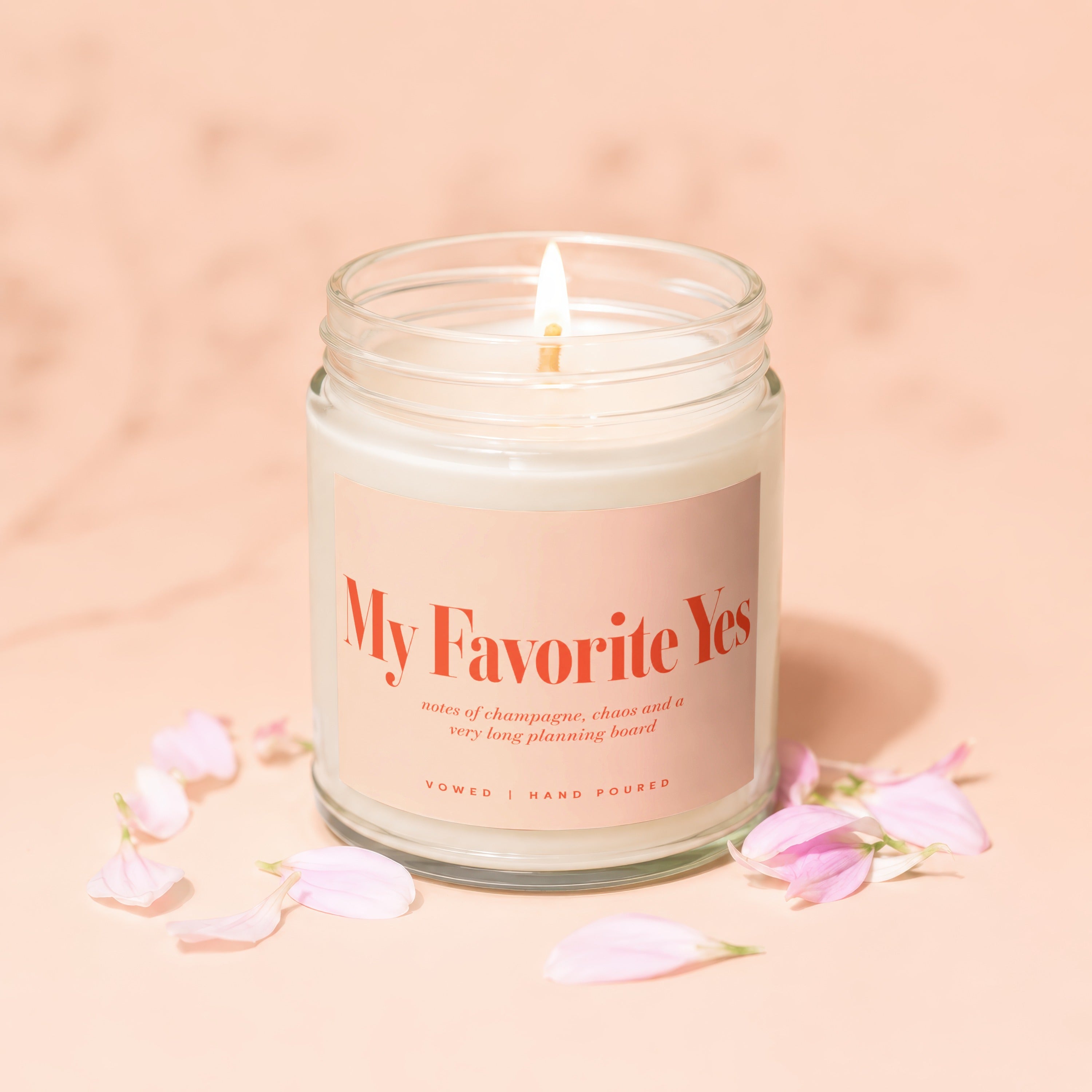 Lit candle, "My Favorite Yes" label, champagne and chaos notes, Vowed, Hand Poured.