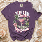 Purple t-shirt graphic with text "This Girl Needs a Margarita" and tropical drink.