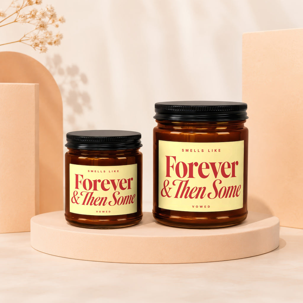 Two amber glass candles with black lids feature yellow labels with red text.