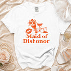 White t-shirt with orange graphic: "Maid of Dishonor," lipstick, flowers, and cocktail glasses.