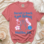 Pink t-shirt with "Sarah's Bach Last Splash Bride" text, champagne glasses, ring, and flower.
