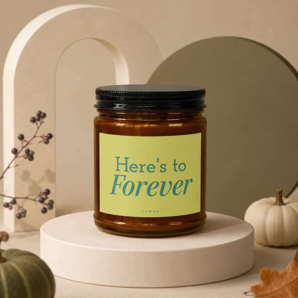 Amber candle with "Here's to Forever" text on a light green label.