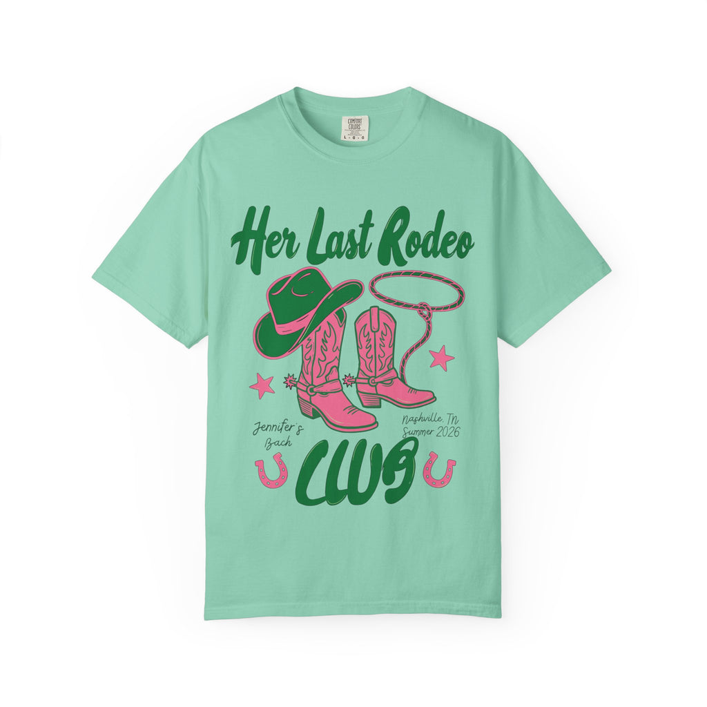 Green t-shirt with "Her Last Rodeo" text, cowboy boots, hat, and lasso.