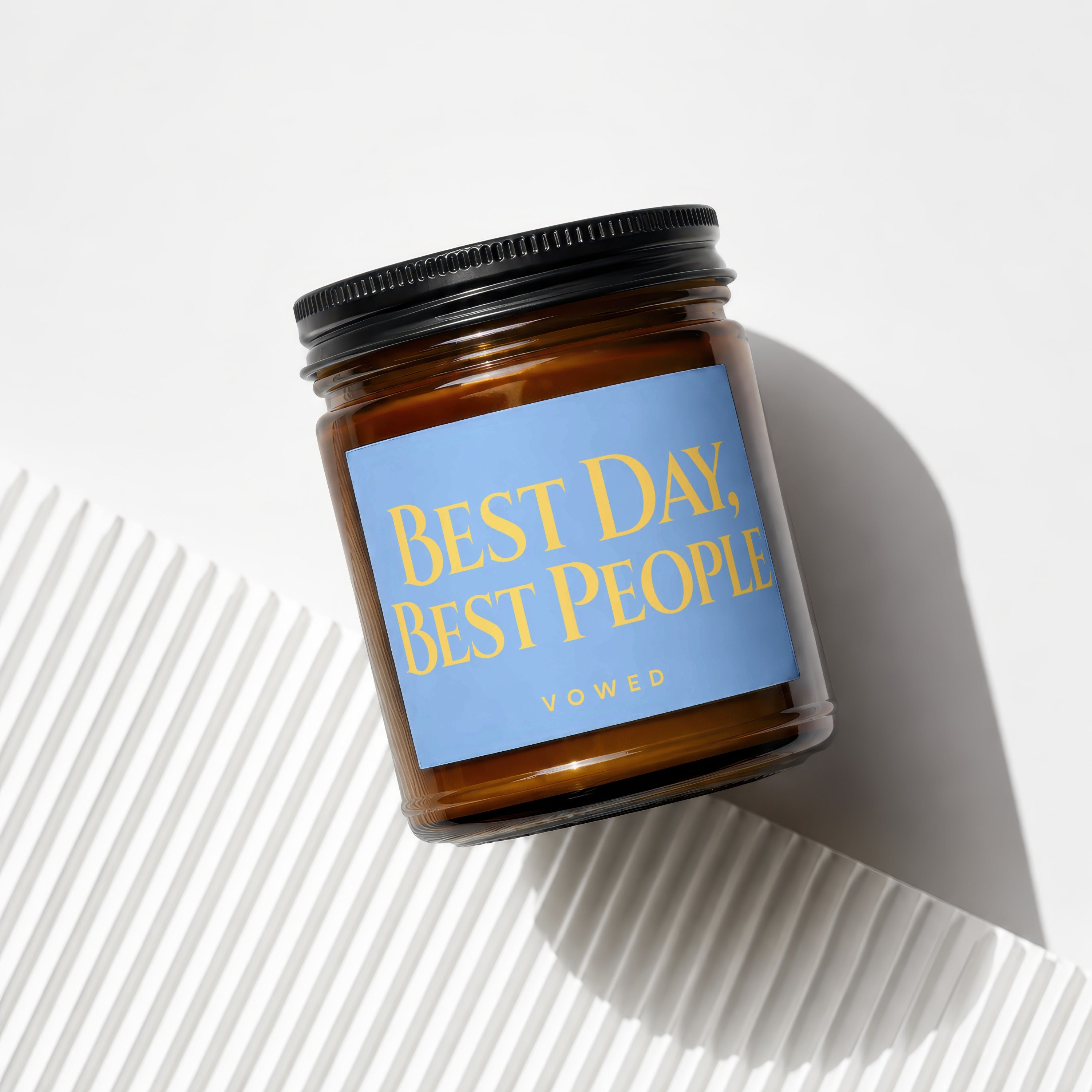 Amber glass candle with blue label reading "BEST DAY, BEST PEOPLE"