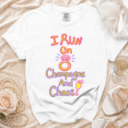 White t-shirt with "I Run On Champagne And Chaos" text and ring graphic.