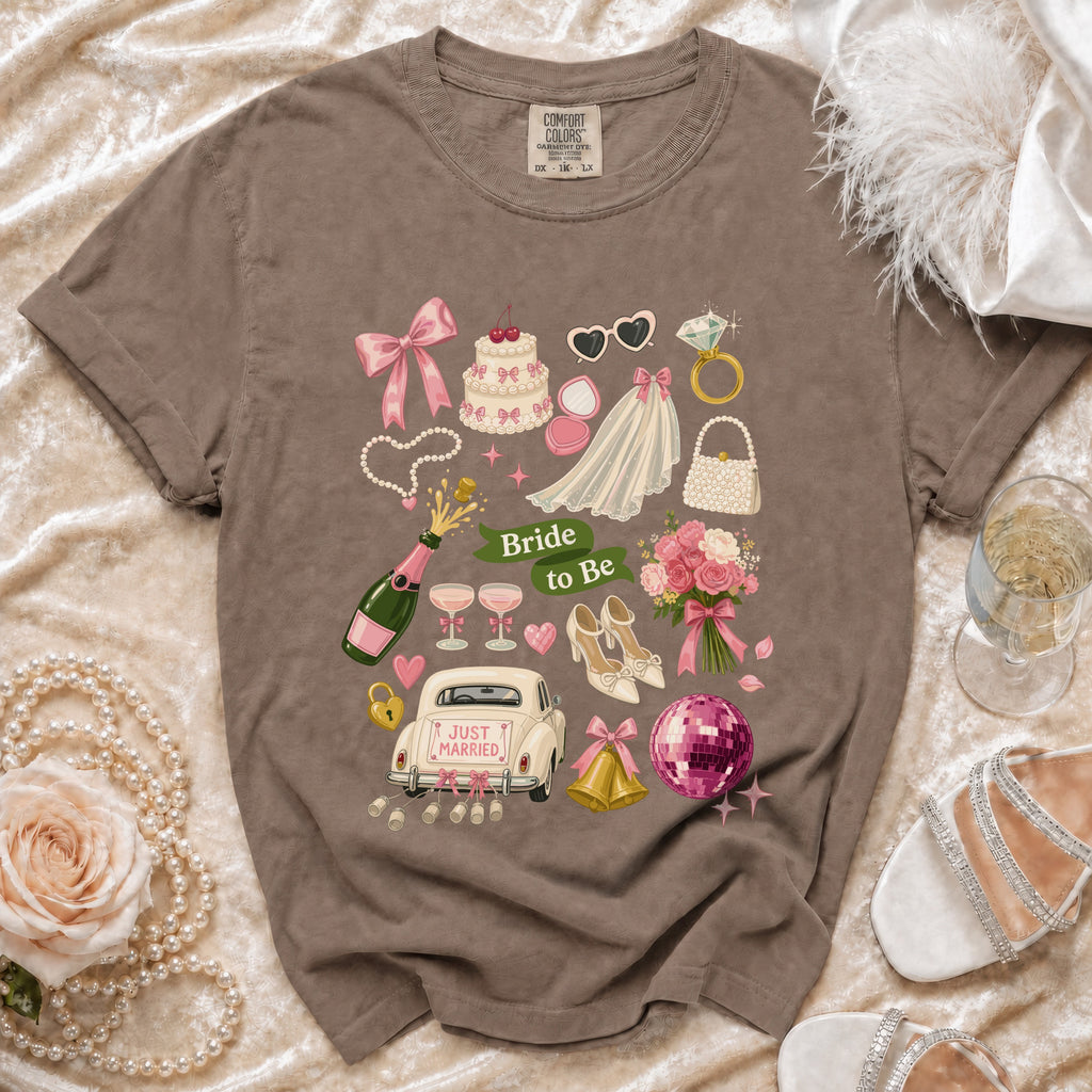 T-shirt with "Bride to Be" graphic featuring wedding items: car, cake, veil, ring, and champagne.