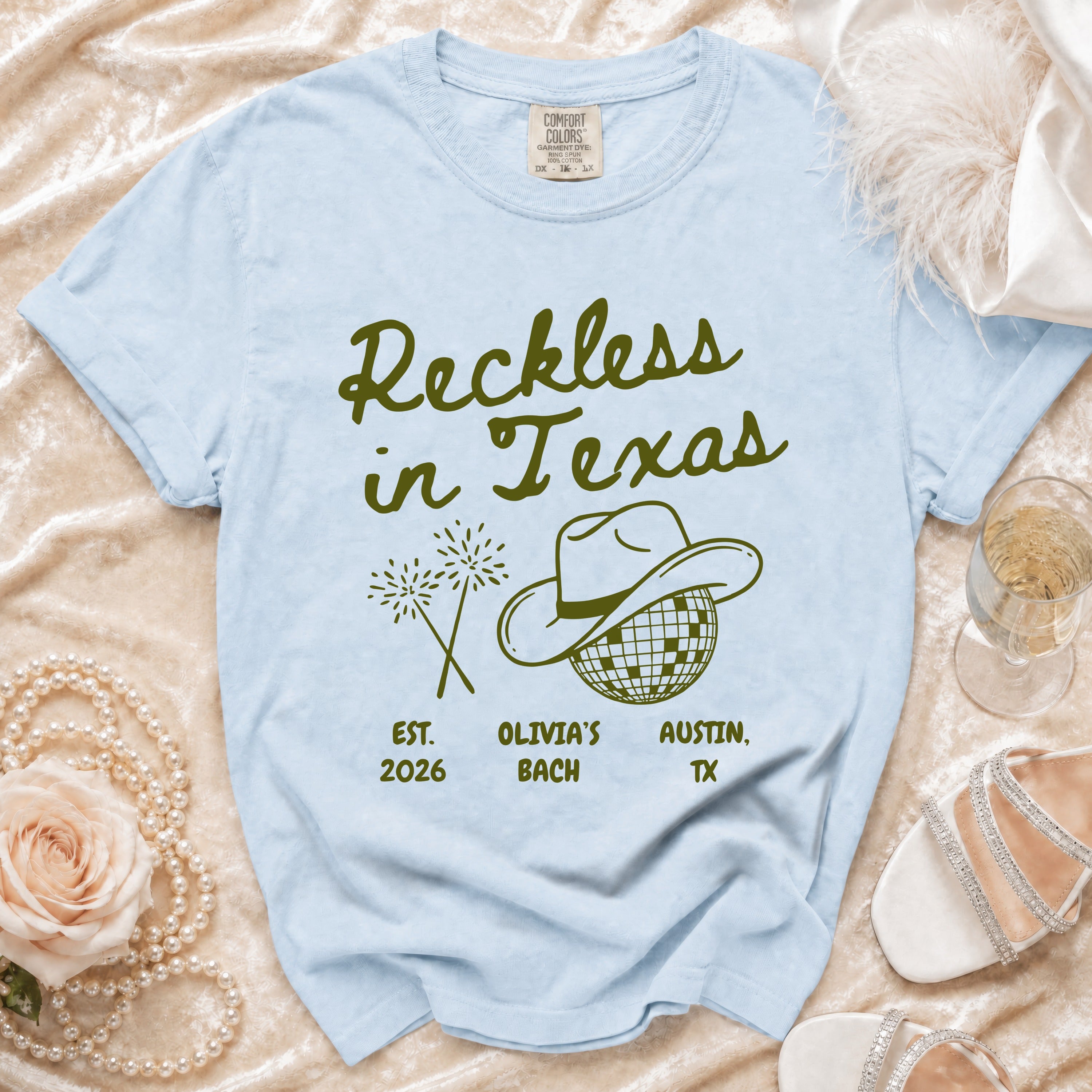 Light blue t-shirt with "Reckless in Texas" and "Olivia's Bach" design.