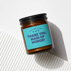 Amber glass candle with a teal label reading "Thank You, Maid of Honor!"