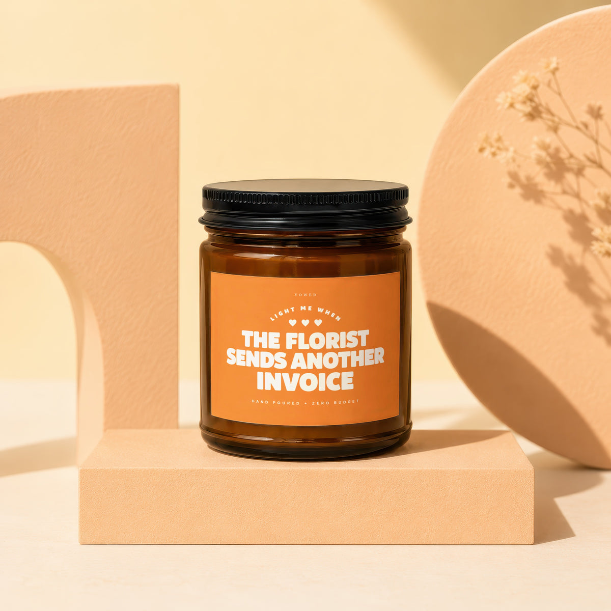 Amber jar candle with "The Florist Sends Another Invoice" text on label.