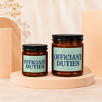 Two amber glass candles with "Officiant Duties" text on light blue labels.