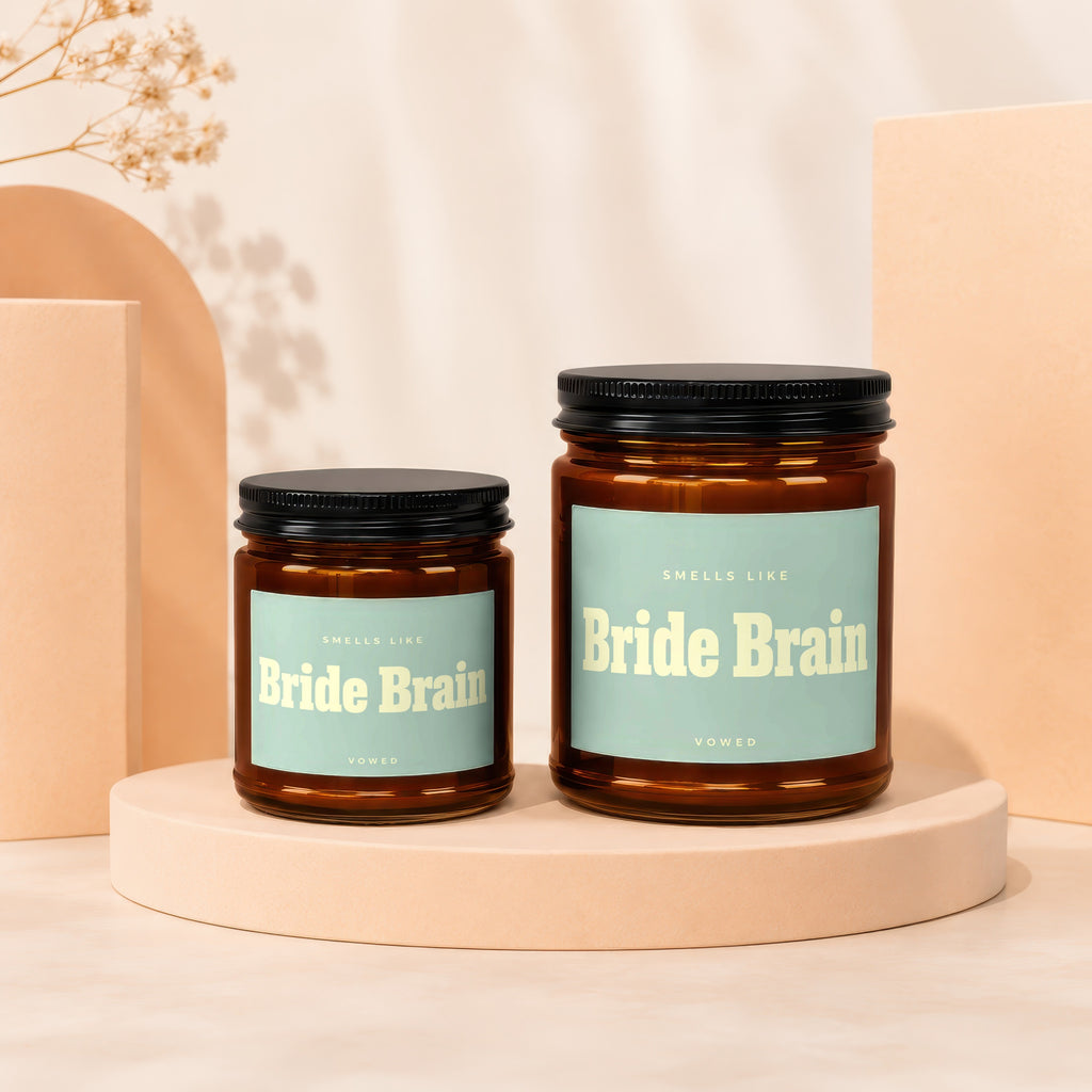 Two amber glass candles labeled "Bride Brain" sit on peach pedestals.