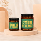 Two glass candles with green labels reading "Certified Off The Market" sit on pedestals.