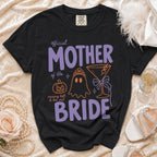 Black Comfort Colors t-shirt with "official MOTHER of the BRIDE" text and Halloween graphics.