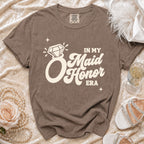 Brown t-shirt with "In My Maid Honor Era" graphic and diamond ring.