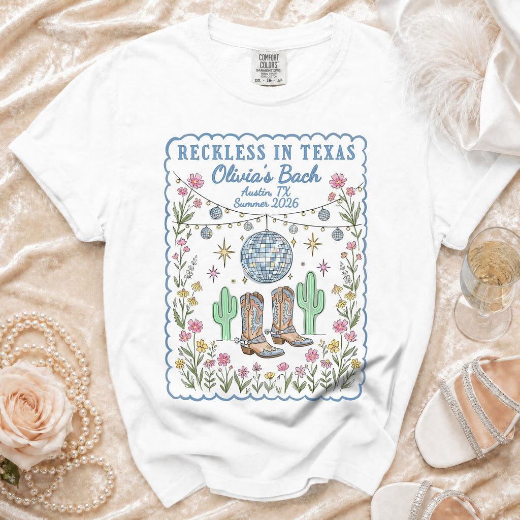 White t-shirt with "Reckless in Texas Olivia's Bach" graphic, cacti, disco ball.