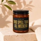 Amber jar candle with black lid and "This Spell Took All Weekend" label.