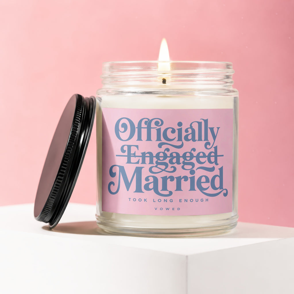 Candle with pink label reading "Officially Engaged & Married Took Long Enough Vowed".